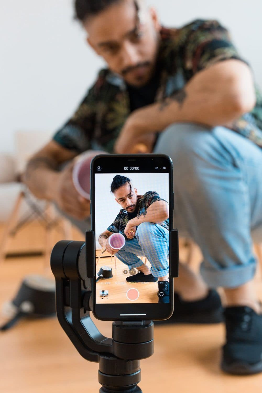 Example video: a creator crouching to film himself with a cup in hand