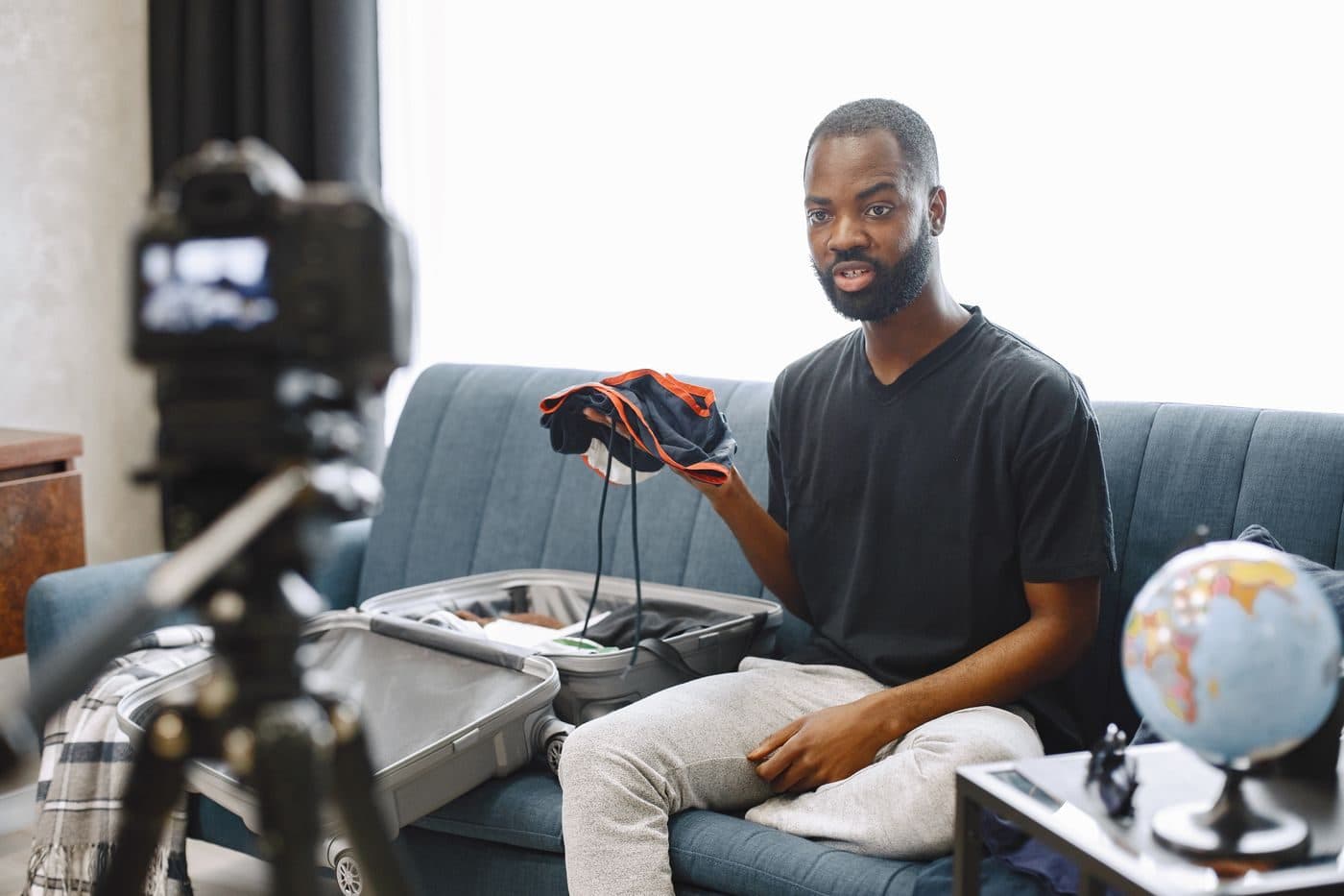 A creator on a sofa holding a product up to a camera