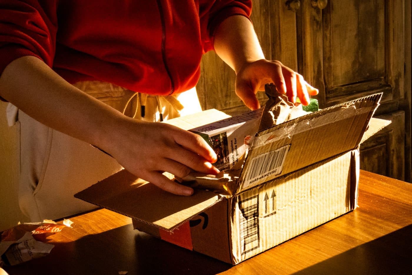 Hands opening a shipped box in warm light